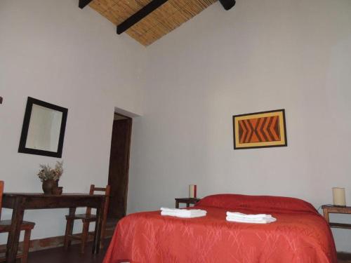 莫利诺斯德马诺洛宾馆的一间卧室配有红色的床和一张桌子