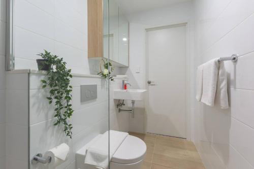悉尼Cozy 2BR w Free Parking Near Westfield Parramatta的白色的浴室设有卫生间和水槽。