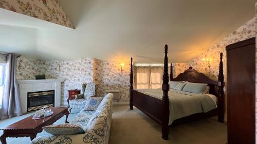 尼亚加拉瀑布白寒木住宿加早餐酒店的一间卧室配有一张床、一张沙发和一个壁炉