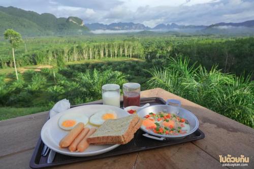 Ban Pha Saeng LangPor Sampao Camp&Resort的早餐托盘包括鸡蛋、烤面包、面包和饮料