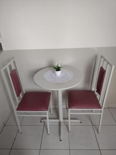 阿拉沙Studio no Centro的一张带两把椅子的白色桌子和花瓶