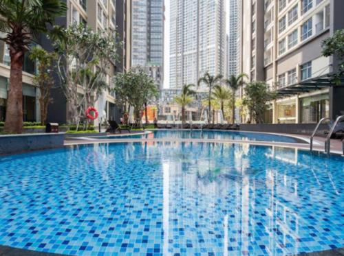 胡志明市Liam Service Apartment - Vinhome Central Park的一座拥有高楼建筑的城市里的大型蓝色游泳池