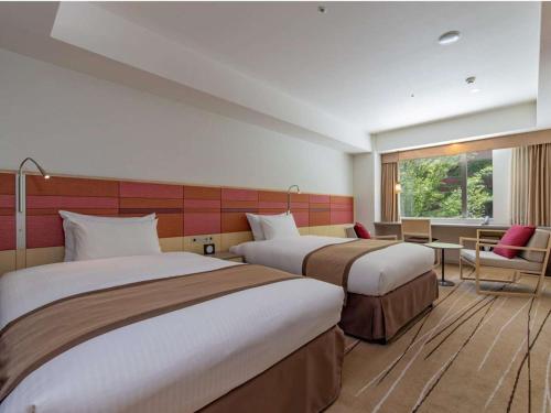 福冈JR九州花博中心酒店的酒店客房设有两张床和窗户。