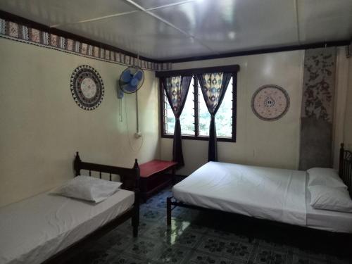 Naviti IslandWAI MAKARE HOMESTAY ROOM 2的两张床位于带窗户的房间内