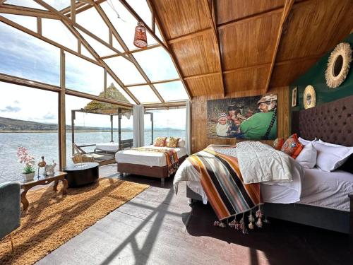 普诺Hotel - Titicaca Dora的一间卧室设有两张床,享有水景