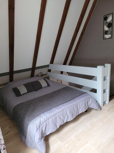 凯泽贝尔Gite Delphine的卧室配有白色的床和木制床头板