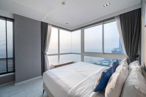 乔木提恩海滩Veranda Pattaya/3BR Seaview/32FL的一间卧室设有一张大床和大窗户