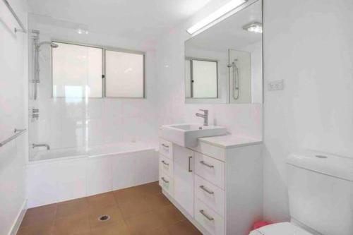 波因特卢考特Treetops on Tramican - Ocean View - sleeps 10的白色的浴室设有浴缸、水槽和卫生间。