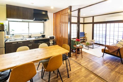 东京Vacation rental Miyabi/downtown/Tokyo airport的厨房以及带木桌和椅子的客厅。