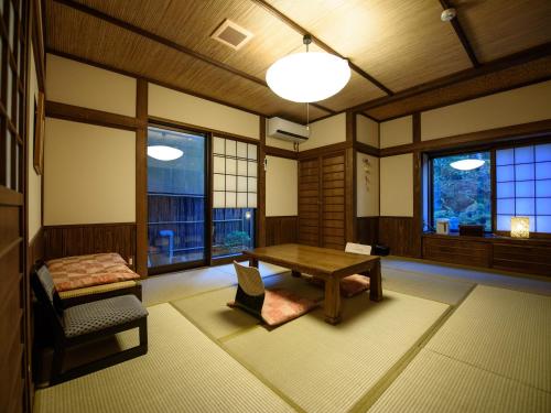 由布市雨诺希拉卡米亚纳吉亚日式旅馆的客房设有桌子、长凳和窗户。