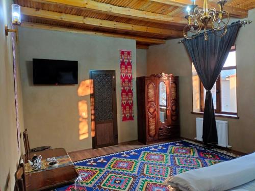 撒马尔罕Darvozai Samarkand guest house的卧室配有一张床,地板上铺有地毯