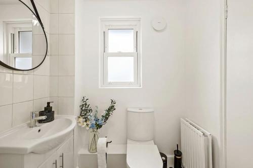 伦敦5 guests 3 beds 1 sofa bed Lewisham的白色的浴室设有卫生间和水槽。