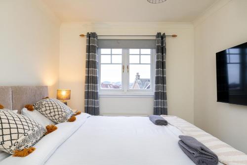 斯特灵4 Bedroom Townhouse in Stirling的卧室配有一张大白色床和窗户