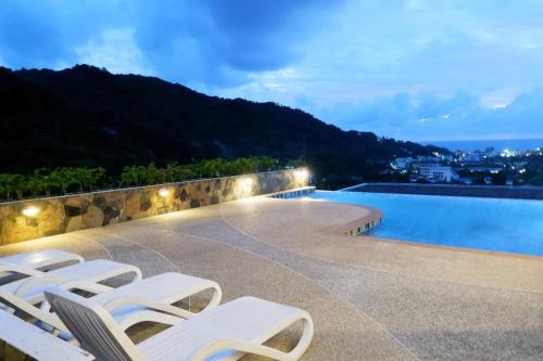 Ban KataKata Ocean View Condominium, Seaview & Luxury K12的一组白色躺椅,位于游泳池旁