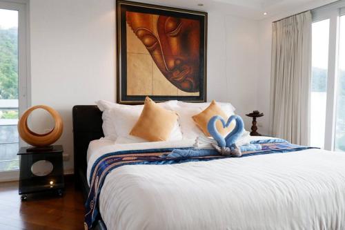 Ban KataKata Ocean View Condominium, Seaview & Luxury K12的一间卧室配有一张床,拥有心灵装饰