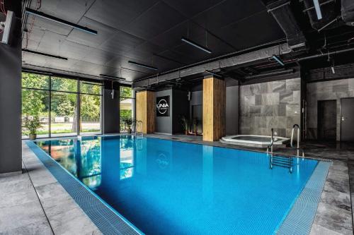 卢布林RS SUITES PRESTIGE Racławickie 10 "best view" HOME & SPA的大楼内一个蓝色的大型游泳池