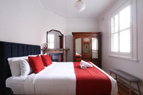悉尼Discover The Rocks - Historical Terrace House的一间卧室配有一张带红色枕头的大床