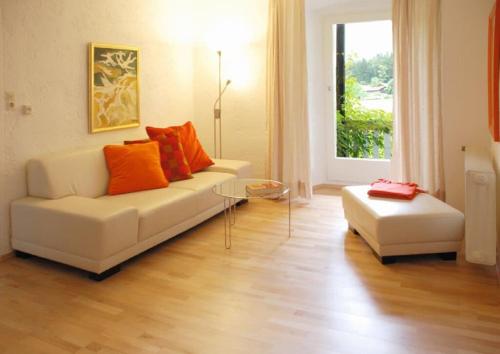 瓦尔德明兴弗兰肯磨酒店的客厅配有白色沙发和橙色枕头。