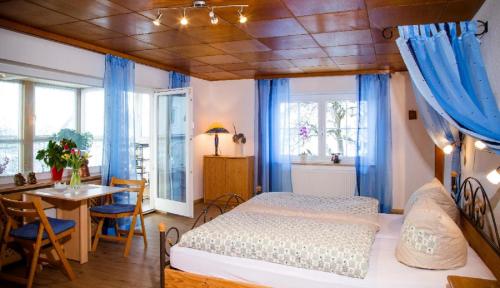 弗赖翁Ferienwohnung "Gaby"的一间卧室配有一张带蓝色窗帘的床和一张桌子