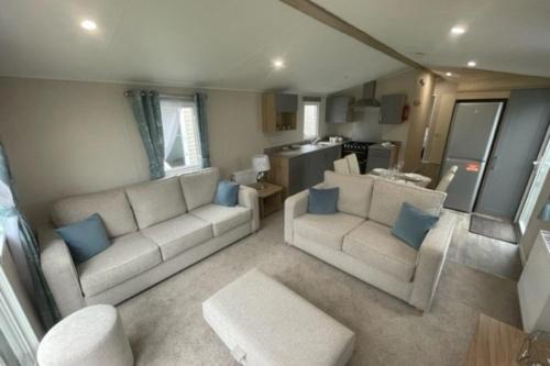 卡纳芬Number 57 Brynteg的客厅配有2张白色沙发和蓝色枕头