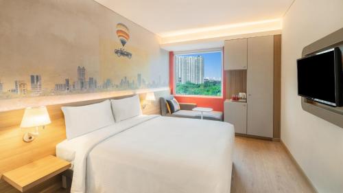 塞恩ibis Thane - An Accor Brand的一间酒店客房,配有白色的床和电视