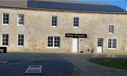 SorinnesGite de la ferme du Ry的带有读出纯混凝土标志的砖砌建筑