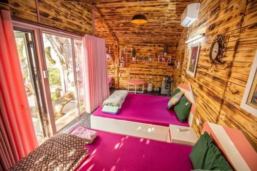 三岛县Roses Villa Tam Dao - Venuestay的小木屋内的一个房间,配有一张紫色的床