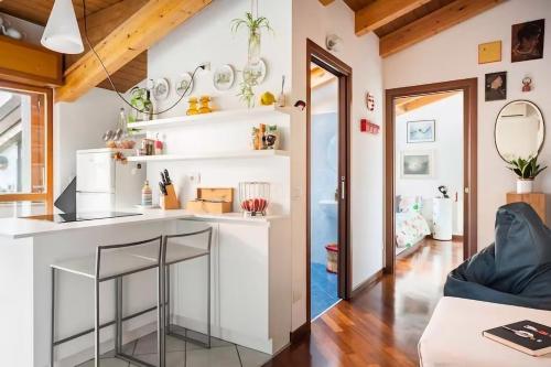米兰Le Domus Milano_Attic with terrace的厨房以及带白色台面的客厅。