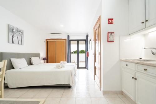 阿尔布费拉Apartamentos Vale de Carros by Umbral的白色客房 - 带床和厨房
