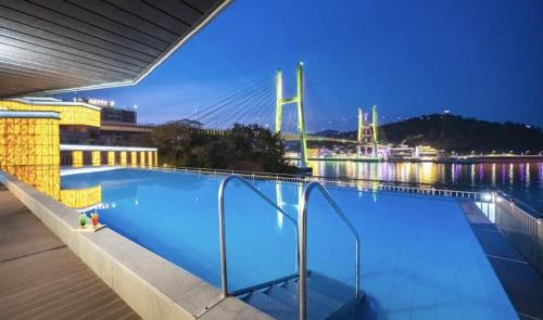 丽水市Yeosu Hotel Haven的一座带桥的夜间游泳池