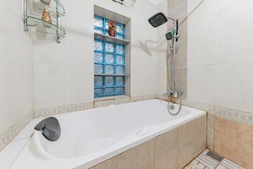 万隆Urbanview Hotel Villa Surya Bandung的带窗户的浴室内的白色浴缸