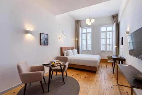 布拉加LP Heritage Apartments的酒店客房带一张床、一张桌子和椅子