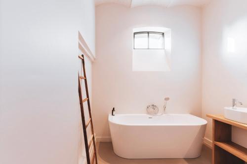 奥德纳尔德Duisbeke Logies的白色的浴室设有浴缸和水槽。
