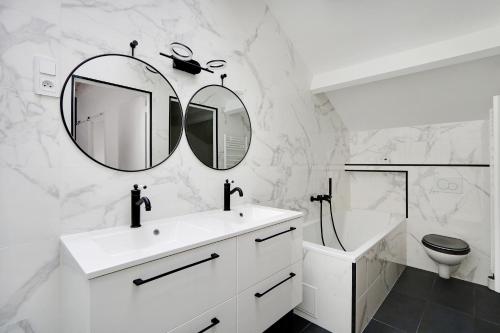 巴黎Pick A Flat's Apartment in La Chapelle - Impasse du Curé的白色的浴室设有水槽和镜子