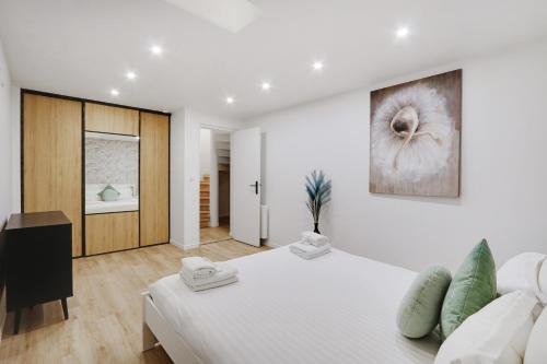 巴黎Pick A Flat's Apartment in La Chapelle - Impasse du Curé的白色卧室设有一张大床和墙上的绘画