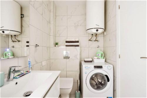 阿德耶PaulMarie Family Apartment Ocean&Mountain View的一间带洗衣机和水槽的浴室