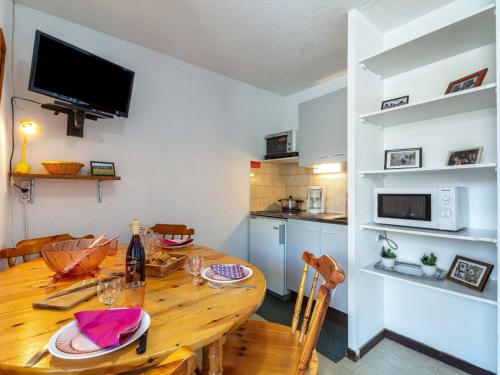 土绪尔Apartment Les Mousquetons-19 by Interhome的厨房以及带木桌的用餐室。
