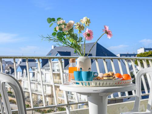 基伯龙Apartment Kérabus-1 by Interhome的阳台上的桌子上放着一盘食物和鲜花