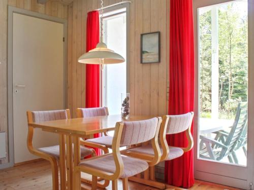 莱斯Holiday Home Gerarda - all inclusive - 4km from the sea by Interhome的一间设有红色窗帘和桌椅的用餐室