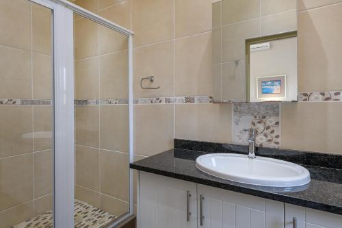 绍斯布鲁姆San Lameer Villa 14321 - 5 Bedroom Deluxe - 10 pax - San Lameer Rental Agency的一间带水槽和淋浴的浴室
