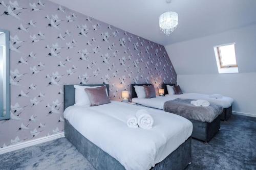 海伍德Lovely three bed home Manchester的一间卧室设有两张床,墙上有鸟