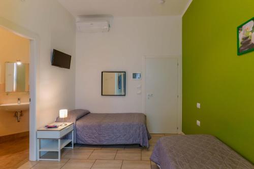 博洛尼亚B&B Bentivogli的一间设有两张床和绿色墙壁的客房