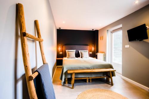 海边的艾格蒙特尼普顿酒店的一间卧室配有一张床、一台电视和一把椅子