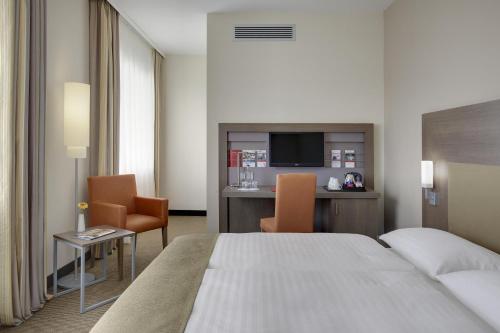 莱比锡莱比锡城际酒店的酒店客房带一张床、一张桌子和椅子