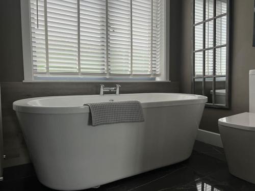 贝尔特比特Contemporary Townhouse Stunning lakeside location的带窗户的浴室内的白色浴缸
