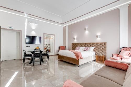 罗马UnoSeiTre - Luxury Apartment & Suite的一间卧室配有一张床、一张桌子和一张沙发