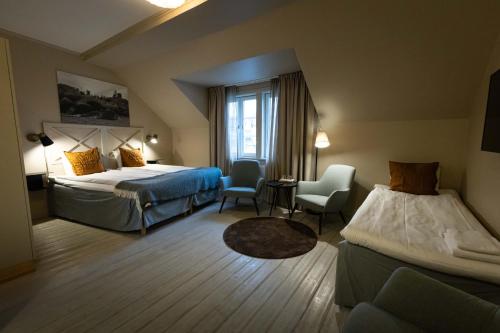 诺尔泰利耶阿特莱特酒店的酒店客房,配有两张床和两把椅子
