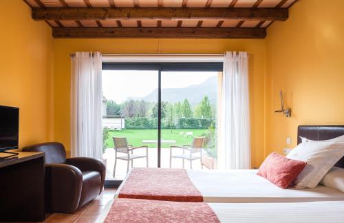 朱内塔斯瓦尔德巴斯酒店的一间卧室设有一张床和一个滑动玻璃门