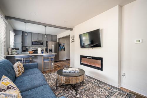 亚特兰大Luxurious 4BR/3BA Stay in NW ATL的一间带蓝色沙发的客厅和一间厨房