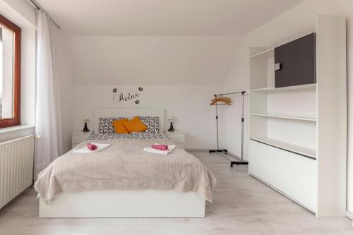 什科菲亚洛卡Apartment Mountain Sunrise的白色卧室配有带橙色枕头的大床